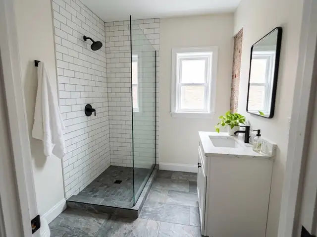 Walk-in shower with white tile and clear glass in a bright bathroom (illustration)